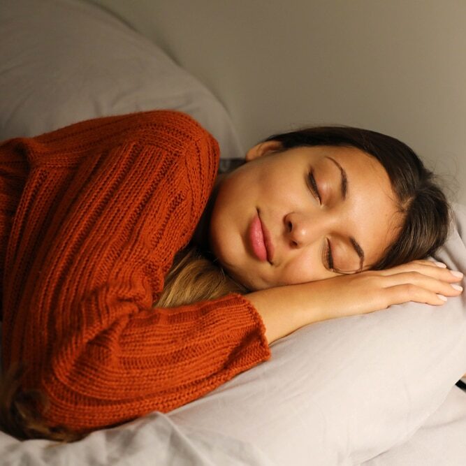 Femme qui dort dans son lit